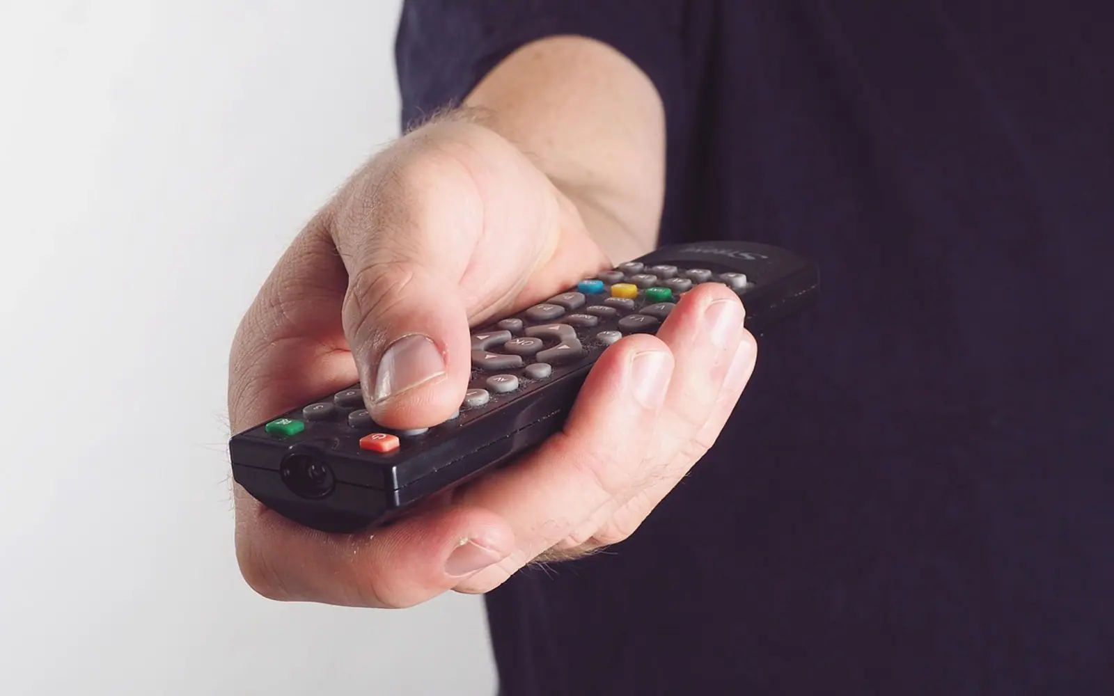 Hand, remote bediehnung and tv